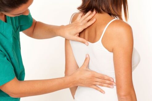 arts onderzoekt de rug met osteochondrose van de wervelkolom